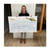 Rachel Brown hands over the cheque to the Warwickshire and Northamptonshire Air Ambulance.