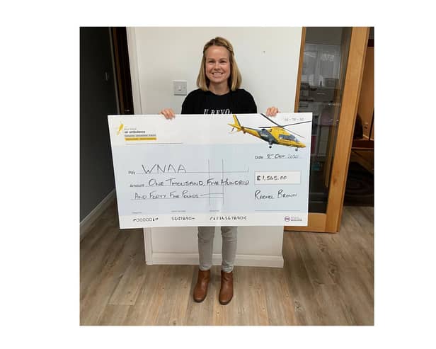 Rachel Brown hands over the cheque to the Warwickshire and Northamptonshire Air Ambulance.