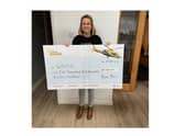 Rachel Brown hands over the cheque to the Warwickshire and Northamptonshire Air Ambulance.