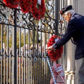 A veteran lays a wreath at Rugby's war memorial gates during the Remembrance ceremony in 2018.