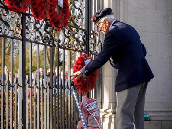 A veteran lays a wreath at Rugby's war memorial gates during the Remembrance ceremony in 2018.