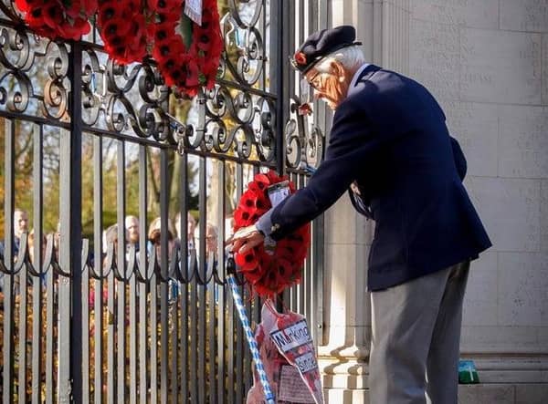 A veteran lays a wreath at Rugby's war memorial gates during the Remembrance ceremony in 2018.