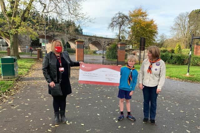 Louise Careless of The Myton Hospices accepts a cheque for £210 from Milo Braley and Sharon Turnbull of The 1st North Leamington Spa Beavers group.