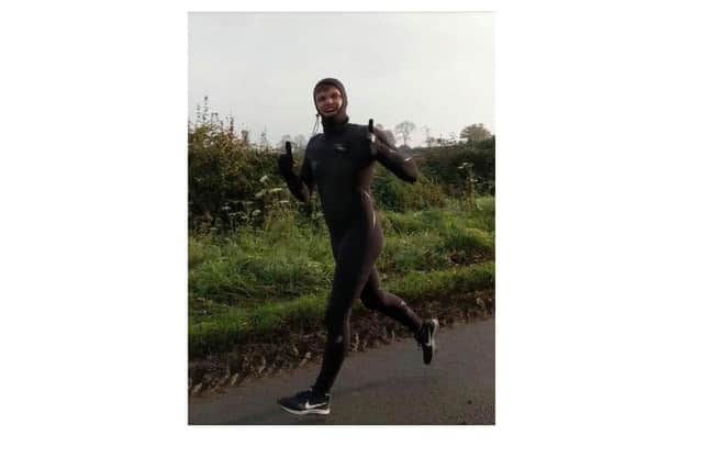 Joshua Evans jogging in a wetsuit for his Movember Madness fundraising challenge.