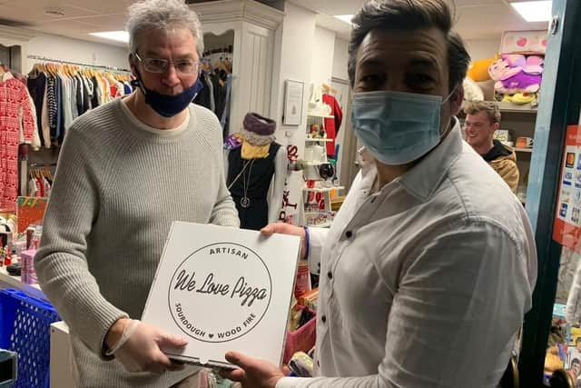 Jose Ribeiro hands over just one of the many pizzas during his latest
delivery to Brian Halford, a volunteer at the Helping Hands soup kitchen. Photo supplied