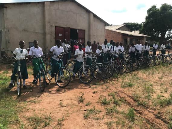The schoolgirls receive their bicycles.