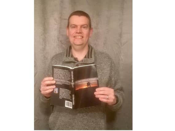 Ed Blackaby with a copy of his book Windmill Heroes 2.