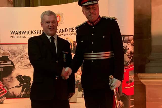 Firefighter Malcolm Gunter on stage with Her Majesty's Lord Lieutenant of Warwickshire Timothy Cox. Photo by Kenilworth Fire Station