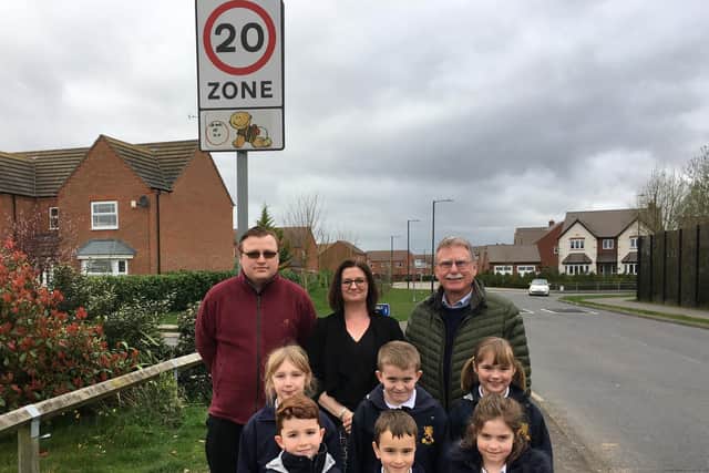 Cllr John Holland,  Angelique Edkins, head teacher, James Ward of County Highways with the six children from Aylesford School whose designs are now in place on 20mph signs. Photo supplied.