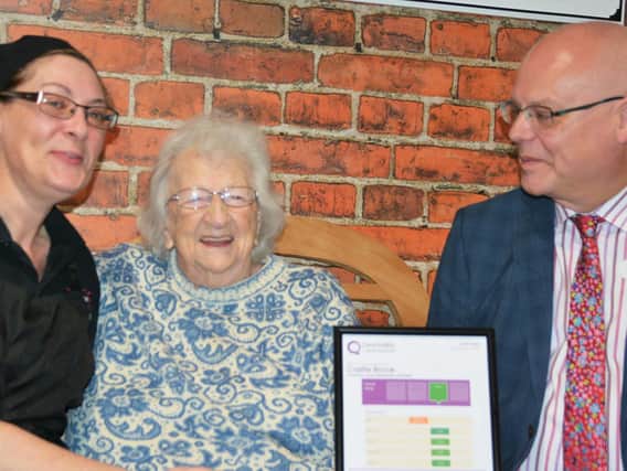 Resident Iris Elliot (centre) admires Castle Brooks good rating with acting general manager Philip Rainsford (right) and hostess Tracey Toogood (left).