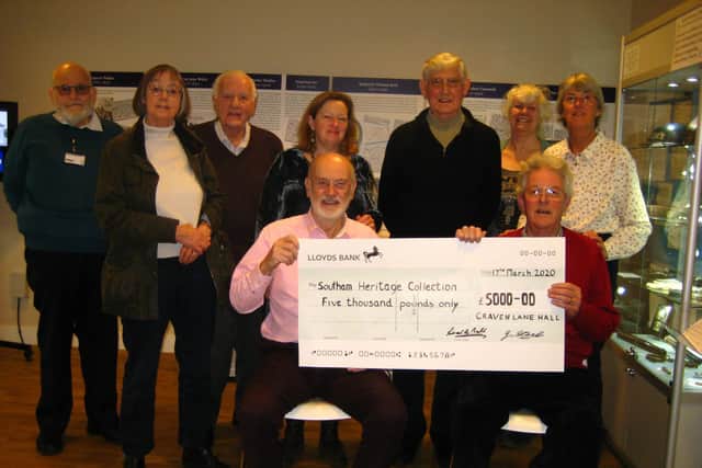Chairman of Southam Heritage Collection Bernard Cadogan receiving a cheque for 5,000 from Jim Steele, chairman of Craven Lane Hall Management Committee. The people in the background are members of both committees.