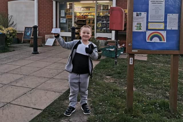 Jack Macaulay delivers a sunflower to the village shop in Lighthorne Heath.