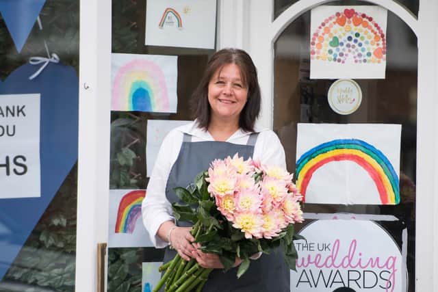 Suzanne Evetts outside her shop in Southam which has rainbow pictures in the window drawn by children in the area. Photo by Du Bois photography