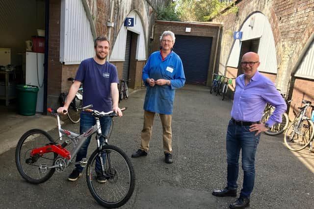 Martin Lythell (Action 21's volunteer bike workshop manager) and Matt Western MP presenting a bike to a keyworker. Photo supplied.