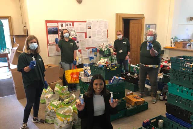 Seanna Hamill hands over the hand sanitiser to the Warwick District Food Bank.