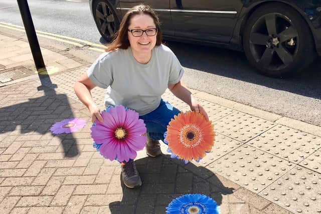 Stephanie Kerr with the bespoke floral stickers to help social distancing in Leamington town centre.