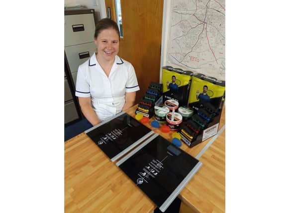 Katherine Thomas is pictured with the upper limb equipment and the two weighing
scales.
