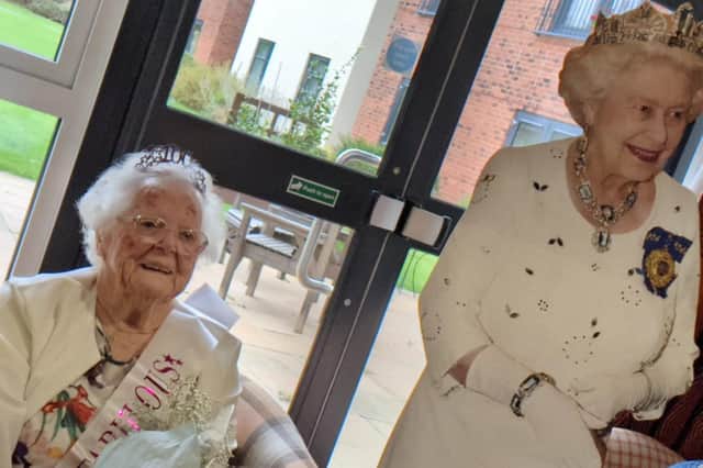 Margaret Whitfield celebrates her 100th birthday with a cut-out of the Queen.