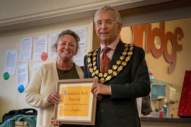 Southam Mayor, Cllr Graham Foster, presents  Debbie of Clippers with a certificate and some goodies in recognition of creating the most voted for Book in a Window. Photo by Karen Tillett.