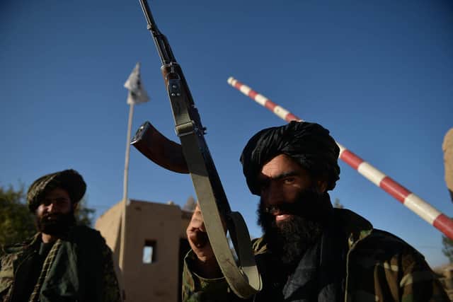TOPSHOT - Taliban fighters stand guard at a police station gate in Ghasabha area in Qala-e-Now, Badghis province on October 14, 2021. (Photo by Hoshang Hashimi AFP) (Photo by HOSHANG HASHIMIAFP via Getty Images).