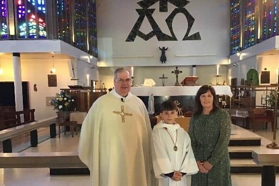 Father Joh Cross and headteacher Debbie Enstone with a pupil at The mass held at the Church of Our Lady to celebrate the 60th anniversary of the opening of Our Lady and St Teresa's Catholic Primary School in Cubbington.