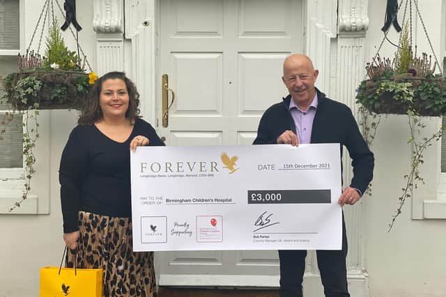 Helen Miles from Birmingham Children’s Hospital receiving the cheque from Forever Living’s managing director Bob Parker outside Longbridge Manor Warwick. Photo supplied