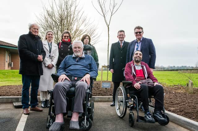 Jeremy Wright MP stands next to the newly planted tree with Castel Froma Neuro Care chief executive Marie Bawden, staff and residents.