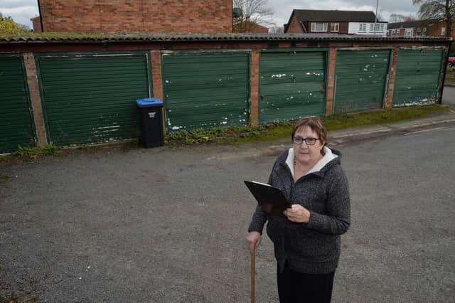 Resident Jane Millington with her petition outside the garages on Orchard Road in Lutterworth.
PICTURE: ANDREW CARPENTER