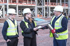 Students present some of the contents of the time capsule to Morgan Sindall Construction project director Richard Frape.