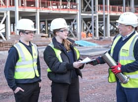 Students present some of the contents of the time capsule to Morgan Sindall Construction project director Richard Frape.