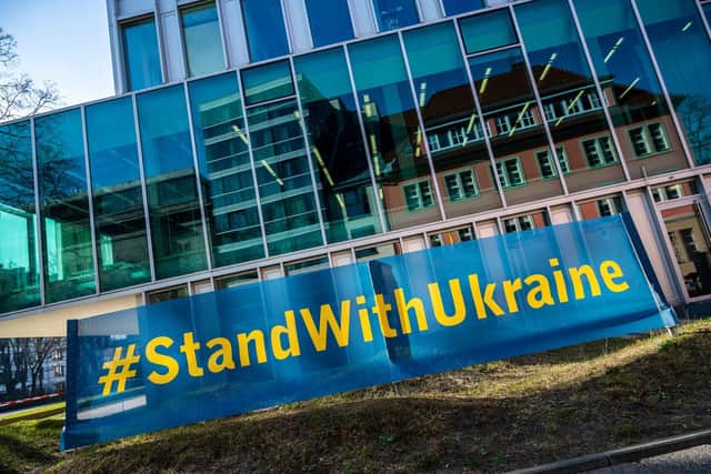 A banner reading: "Stand with Ukraine" is seen opposite the Ukraine's embassy in Berlin on March 2, 2022, after Russian troops invaded the Ukraine. (Photo by John MACDOUGALL / AFP) (Photo by JOHN MACDOUGALL/AFP via Getty Images)