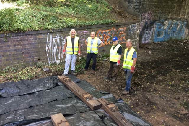 Volunteers laying a small section of railway track on the walk - a feature which serves to remind residents of the line's history.