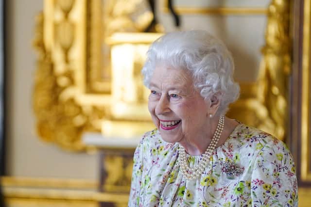 WINDSOR, ENGLAND - MARCH 23: Queen Elizabeth II smiles as she arrives to view a display of artefacts from British craftwork company, Halcyon Days, to commemorate the company's 70th anniversary in the White Drawing Room at Windsor Castle, on March 23, 2022 in Windsor, England. The Queen viewed a selection of hand-decorated archive enamelware and fine bone china, including their earliest designs from the 1950s. (Photo Steve Parsons - WPA Pool/Getty Images)