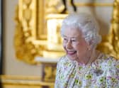 WINDSOR, ENGLAND - MARCH 23: Queen Elizabeth II smiles as she arrives to view a display of artefacts from British craftwork company, Halcyon Days, to commemorate the company's 70th anniversary in the White Drawing Room at Windsor Castle, on March 23, 2022 in Windsor, England. The Queen viewed a selection of hand-decorated archive enamelware and fine bone china, including their earliest designs from the 1950s. (Photo Steve Parsons - WPA Pool/Getty Images)
