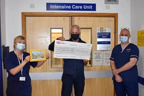 Alan Jennings presents the cheque for £2,000 to staff at Warwick Hospital's intensive care unit.