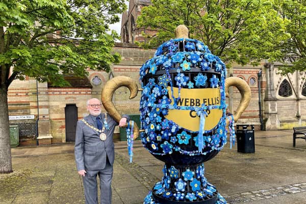 Rugby mayor Cllr Bill Lewis next to the yarn-bombed cup. Photo courtesy of Karen Handley.