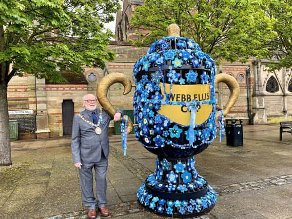Rugby mayor Cllr Bill Lewis next to the yarn-bombed cup. Photo courtesy of Karen Handley.