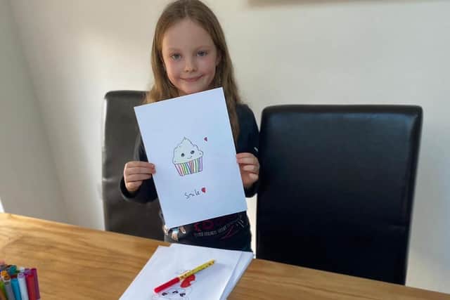 Sophia with one of her drawings.