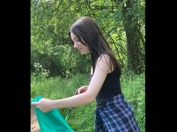 Hannah Deaves litter picking on the Cawston Greenway.