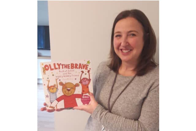 Rachel Ollerenshaw with 'Back At School and the Wibbly Wobbly Tummy', the third in the Olly The Brave series of books produced by Molly Olly’s Wishes. Photo supplied