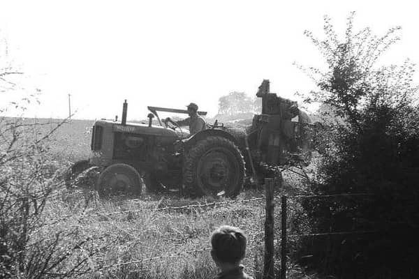 The way we were – a small boy watches a tractor in a Warwickshire field.