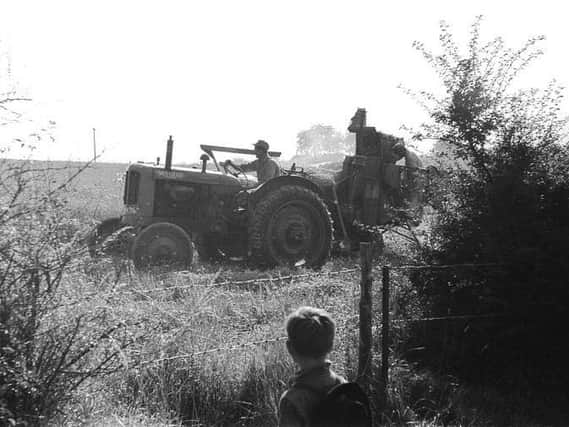 The way we were – a small boy watches a tractor in a Warwickshire field.