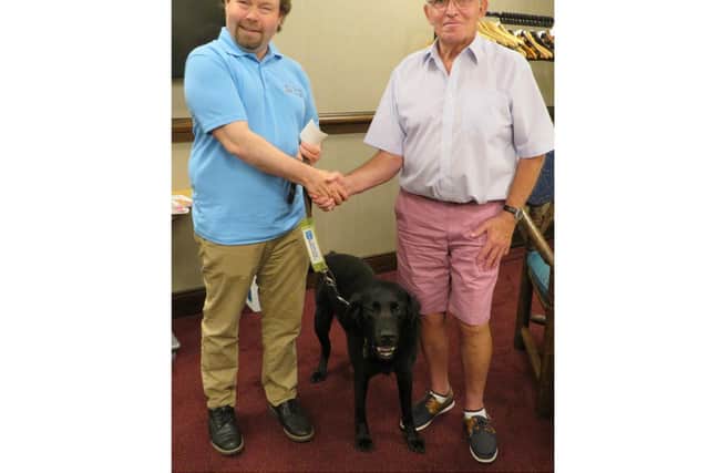 Past President David Brain hands a donation to Martyn Parker (and Wheeler) from Guide Dogs. Photo supplied