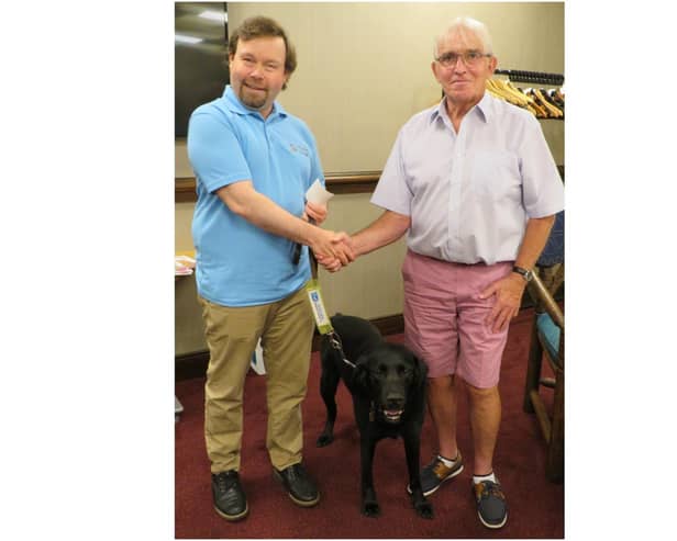 Past President David Brain hands a donation to Martyn Parker (and Wheeler) from Guide Dogs. Photo supplied