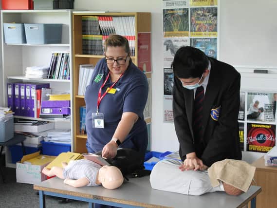 Nurse Anneke shows Avon Valley pupil Tom McGee how to perform CPR.