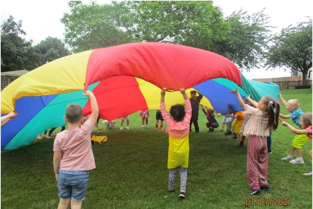 Reception playing with the parachute on the field at the 50th celebration. Photo supplied