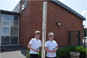 Standing next to their school’s Peace Pole, Ethan Flint and and Oliver Rist. Photo supplied