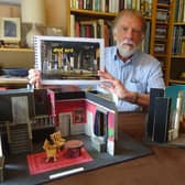 Designer John Ellam with models of two stage sets featured in the new book.