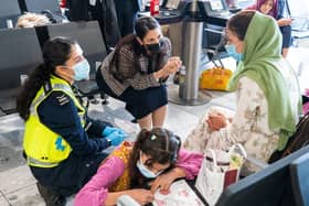 LONDON, ENGLAND - AUGUST 26: Home Secretary Priti Patel (2nd left) talking to Malalai Hussiny (wearing green headscarf) a refugee from Afghanistan who arrived on a evacuation flight at Heathrow Airport on August 26, 2021 in London, England. Ministry of Defence figures put the number of people evacuated by the UK since August 13 at 9,226, but there are thousands feared to be remaining. Foreign Secretary Dominic Raab has said the UK will use "every hour" left to evacuate people from Afghanistan as he declined to rule out British troops having to leave by the end of Friday. (Photo by Dominic Lipinski - WPA Pool/Getty Images)