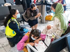 LONDON, ENGLAND - AUGUST 26: Home Secretary Priti Patel (2nd left) talking to Malalai Hussiny (wearing green headscarf) a refugee from Afghanistan who arrived on a evacuation flight at Heathrow Airport on August 26, 2021 in London, England. Ministry of Defence figures put the number of people evacuated by the UK since August 13 at 9,226, but there are thousands feared to be remaining. Foreign Secretary Dominic Raab has said the UK will use "every hour" left to evacuate people from Afghanistan as he declined to rule out British troops having to leave by the end of Friday. (Photo by Dominic Lipinski - WPA Pool/Getty Images)